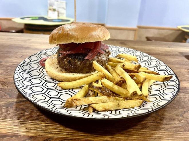 Hamburguesa de la casa con cebolla encurtida y patatas caseras